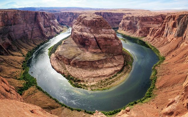 The Colorado River curving in a deep horseshoe loop through red sandstone cliffs at Horseshoe Bend