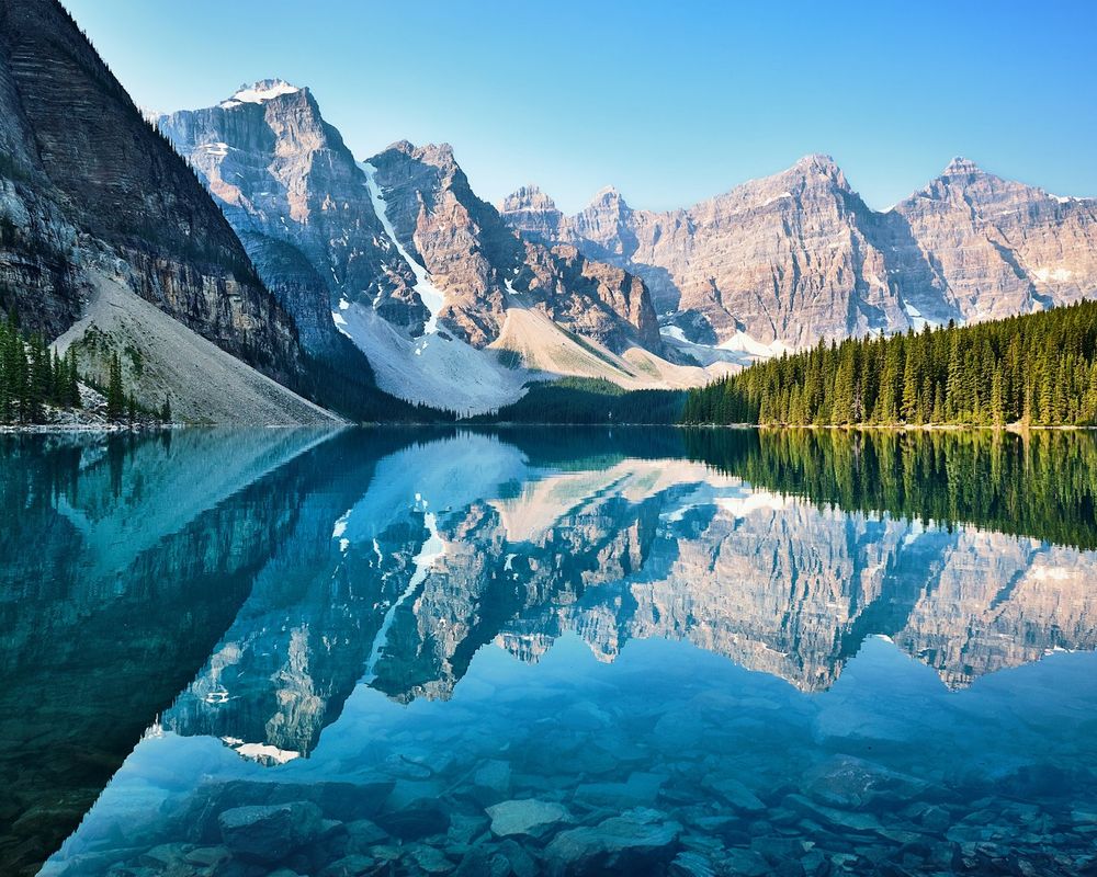 Snowy peaks of the Valley of the Ten Peaks reflected in the turquoise water of Moraine Lake in Banff
